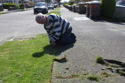 a dedicated resident trimming the grass outside his home